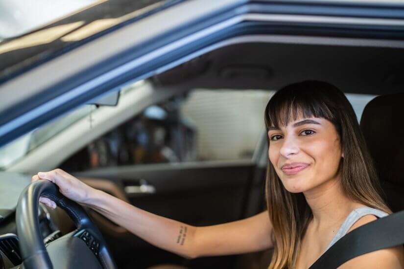 Mulher jovem dirige seu carro